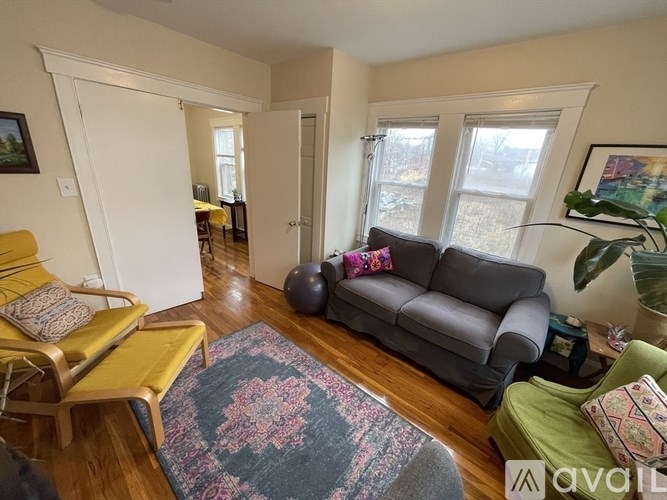 A living room with a grey couch and a yellow chair.