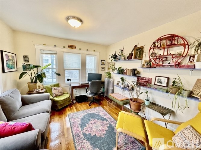 A living room with a grey couch, a yellow chair, and a rug.