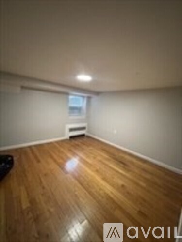 A room with wooden flooring and a window.
