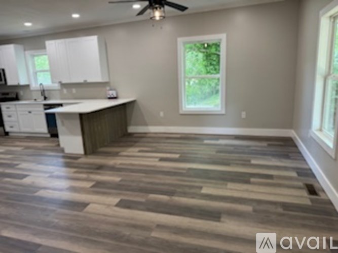 A kitchen with a large island and a ceiling fan.