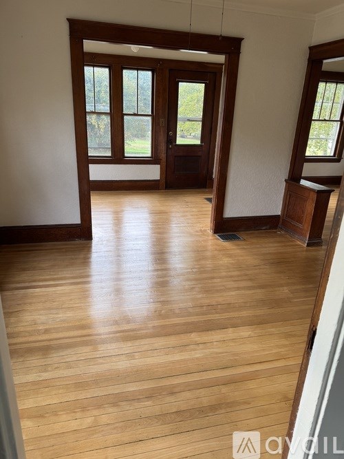 A room with wooden floors and a large wooden door.