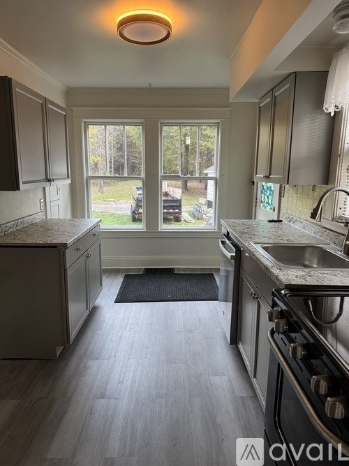 A kitchen with a black oven and a window.
