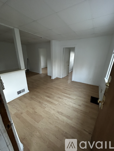 A room with wooden flooring and white walls.