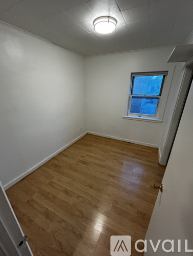 A room with wooden flooring and a window.