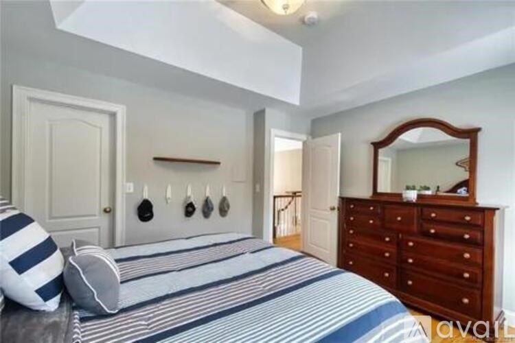 A bedroom with a bed, dresser, and mirror.