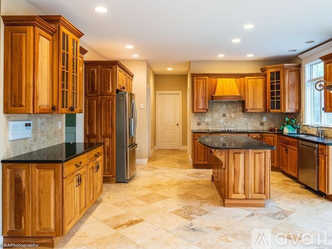 A living room with a fireplace, a chair, and a vase of flowers.