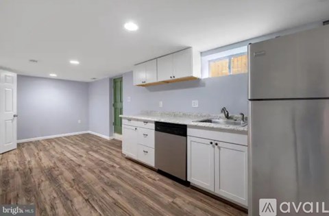 A kitchen with wooden floors and stainless steel appliances.