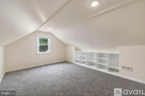 A room with a window and a carpeted floor.