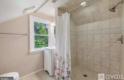 A bathroom with a window and a shower.