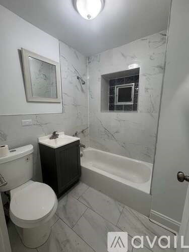 A bathroom with a toilet, sink, and bathtub.