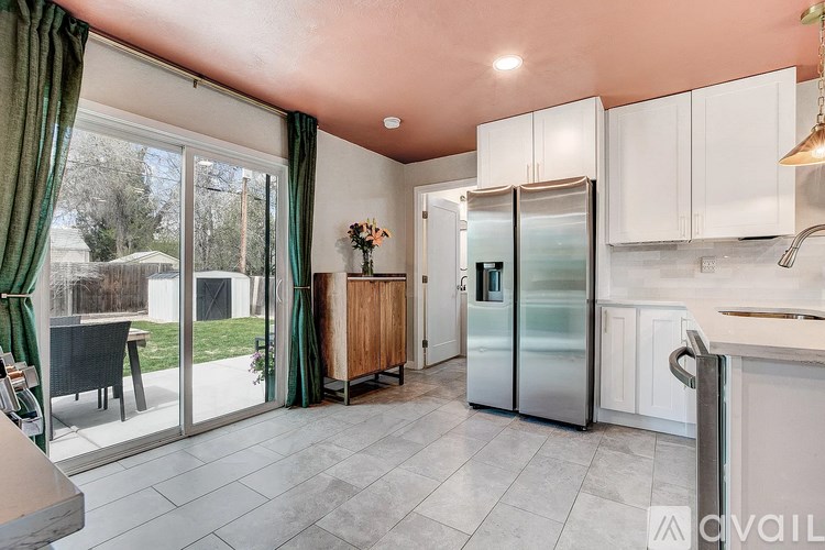 A kitchen with white cabinets and a refrigerator.