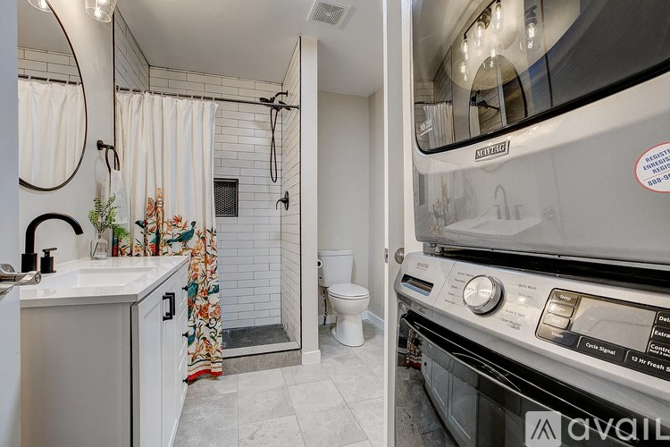 A modern kitchen with a washing machine and dryer built into the cabinetry.