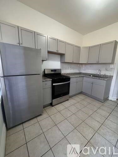 A kitchen with a refrigerator, oven, and cabinets.