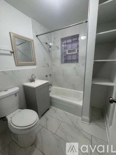 A bathroom with a toilet, sink, and bathtub.