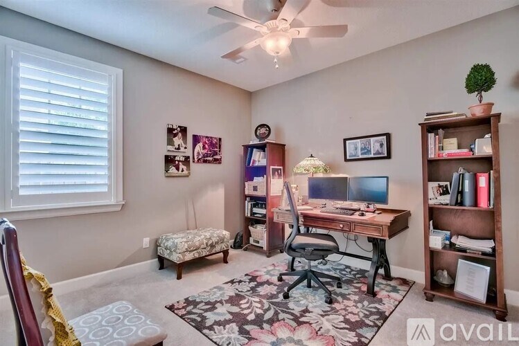 A room with a desk, chair, and bookshelf.