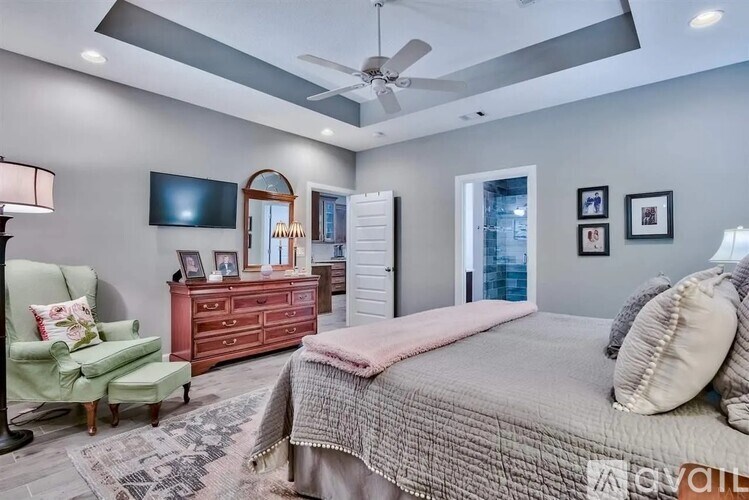 A bedroom with a bed, a chair, and a dresser.