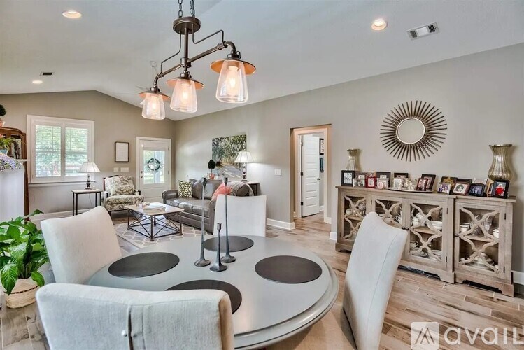 A modern living room with a circular table and a chandelier.