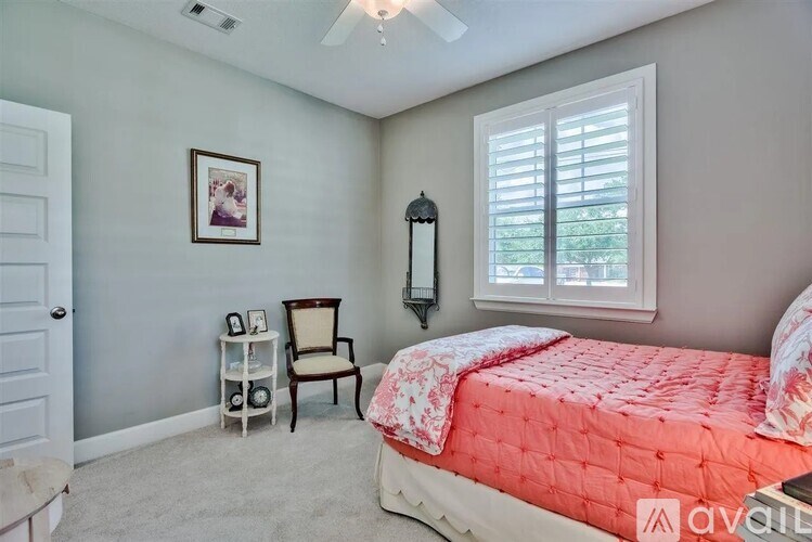 A bedroom with a bed, chair, and picture frame on the wall.