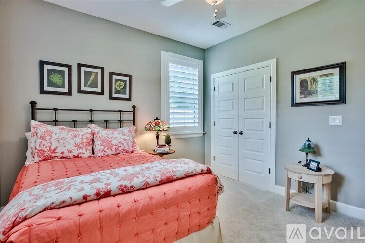 A bedroom with a large bed and a ceiling fan.