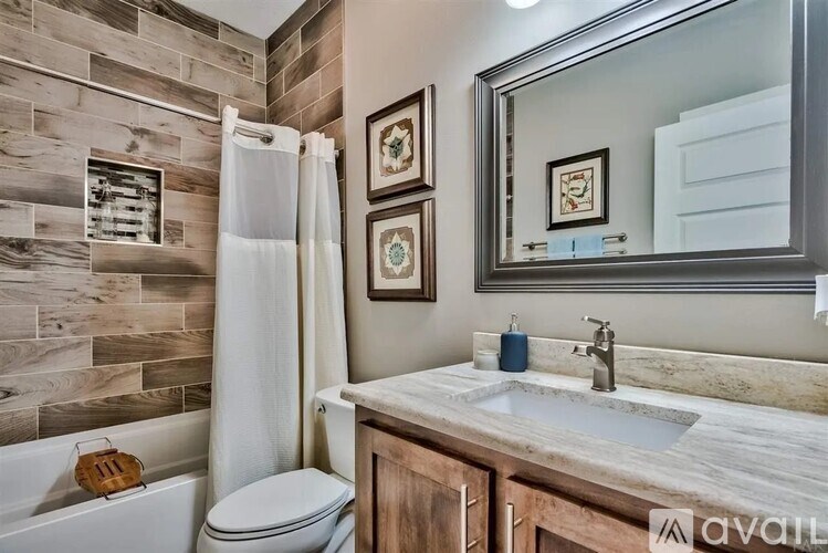 A bathroom with a marble countertop and a wooden cabinet.