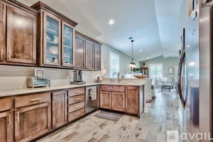 A kitchen with wooden cabinets and a refrigerator.