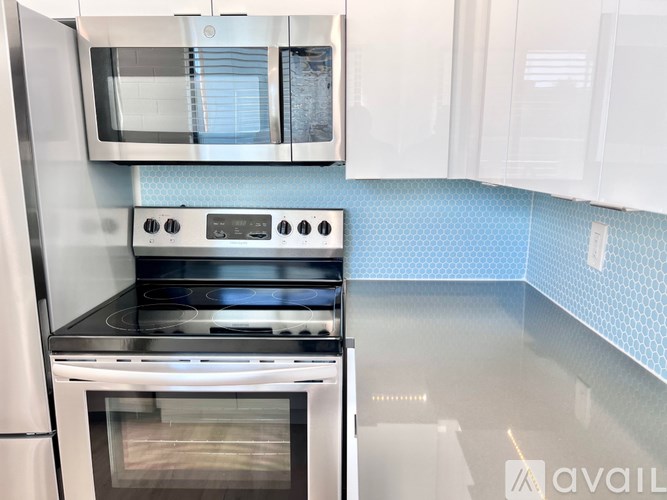 A modern kitchen with a stove top oven and microwave above it.