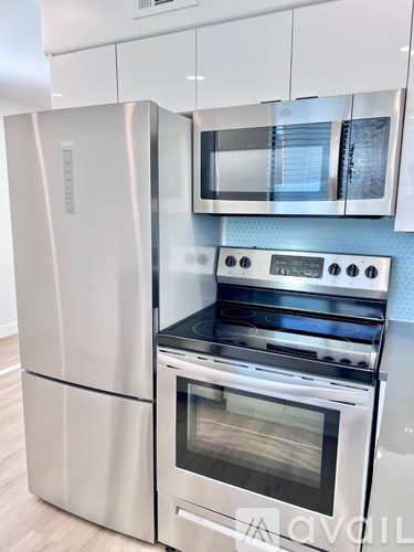 A modern kitchen with a stainless steel refrigerator and oven.