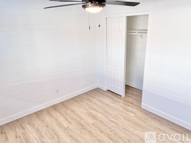 A room with a ceiling fan and a white door.