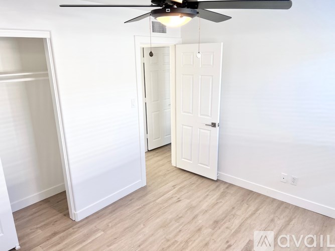A room with a ceiling fan and a door.