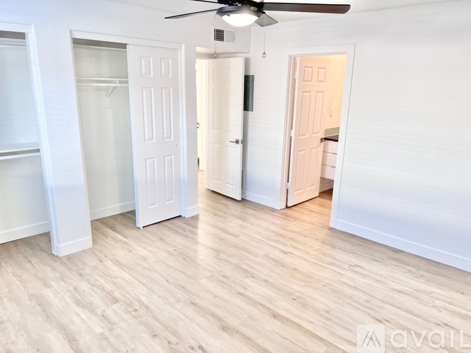 A room with a ceiling fan and wooden flooring.