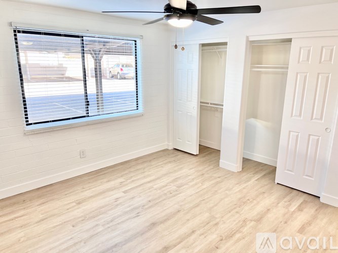 A room with a ceiling fan and a window with blinds.