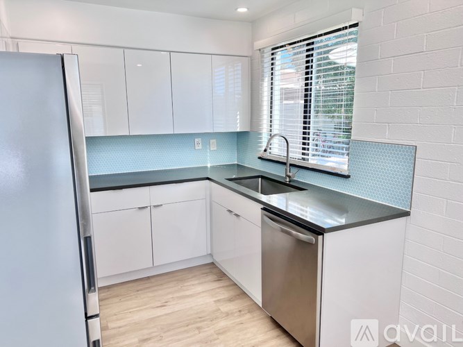 A kitchen with white cabinets and a stainless steel dishwasher.