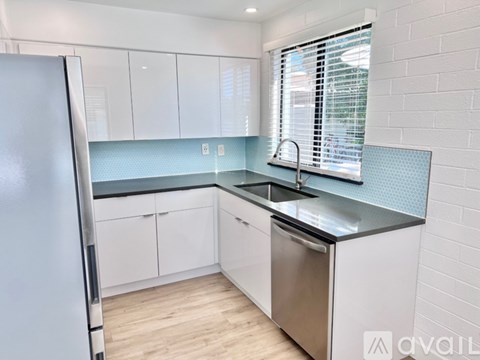 A kitchen with white cabinets and a stainless steel dishwasher.