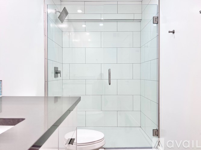 A modern bathroom with a glass shower stall and a toilet.