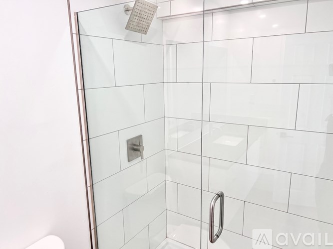 A shower area with a glass door and a shower head.