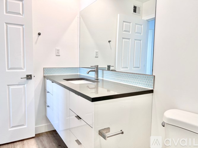 A bathroom with a sink, mirror, and toilet.