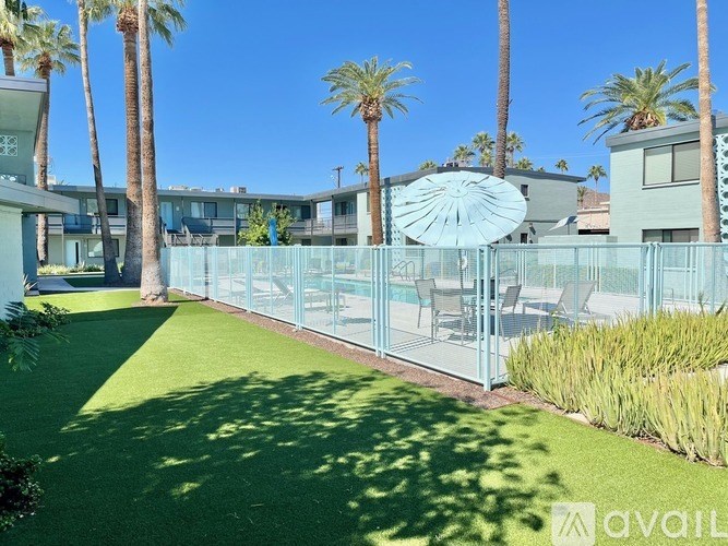 A sunny day at a residential area with a green lawn and palm trees.