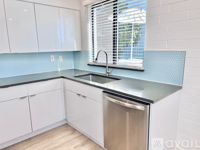 A kitchen with white cabinets and a stainless steel dishwasher.