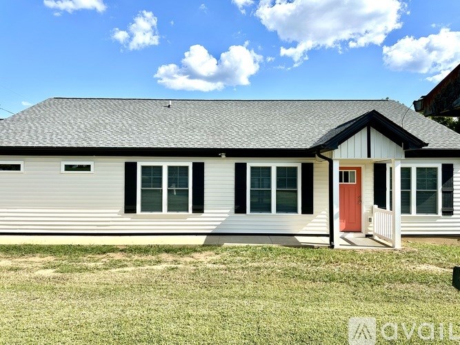 A house with a red door and a grey roof.