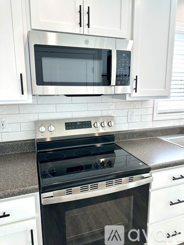 A modern kitchen with a stove and microwave above it.