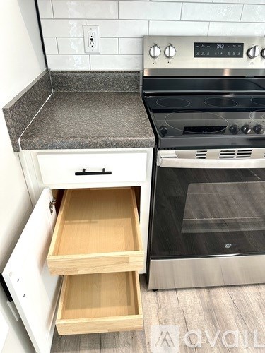 A modern kitchen with a stainless steel oven and a granite countertop.