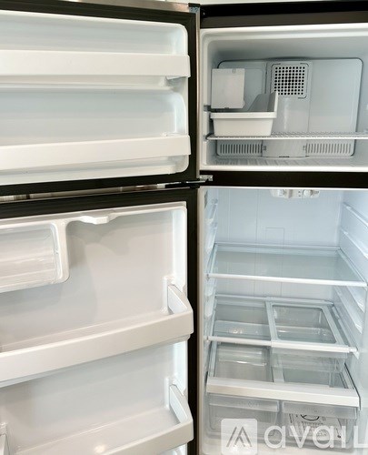 A white refrigerator with the door open showing the shelves and drawers.