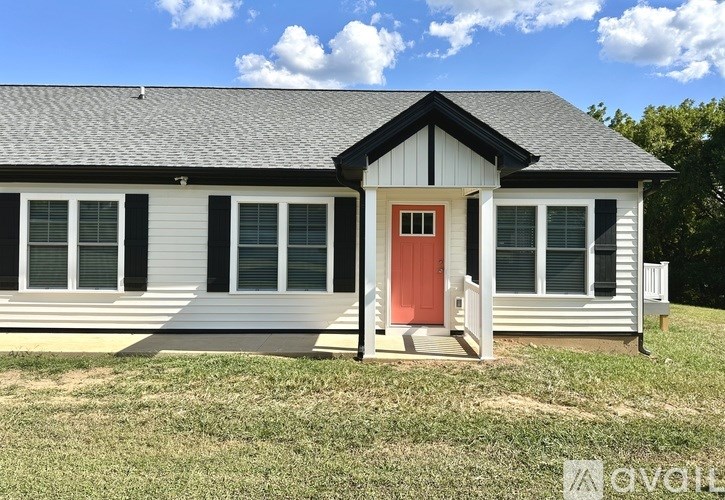 A small house with a red door and a grey roof.
