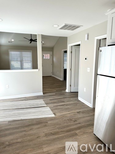 A kitchen with a white fridge and a striped rug on the floor.