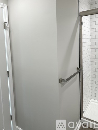 A white door with a silver handle and a white wall.
