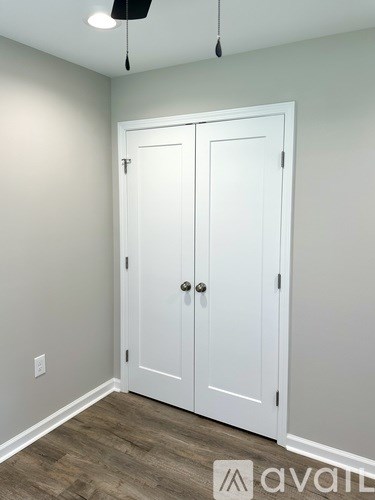 A white double door with a black handle is closed.