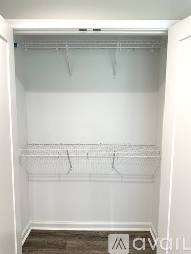 A white closet with three shelves and a door open.