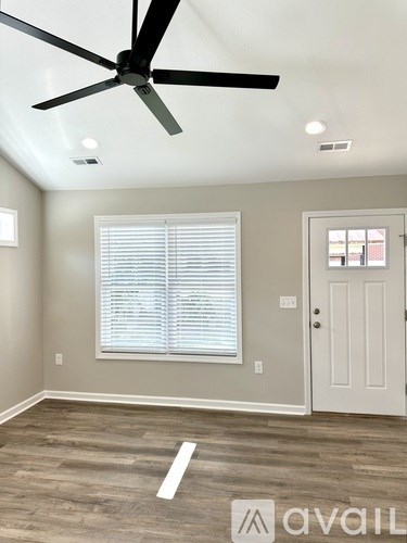 A room with a ceiling fan and a door.