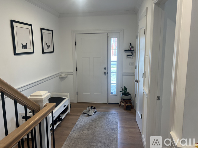 A hallway with a white door and two framed pictures on the wall.
