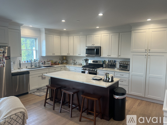 A kitchen with white cabinets and a large island.